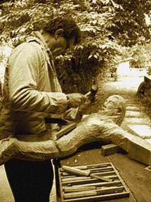 Pendant un stage, une personne sculpte un Christ en bois de tilleul