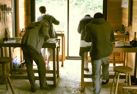 Quatre stagiaires en train de travailler à leur établi